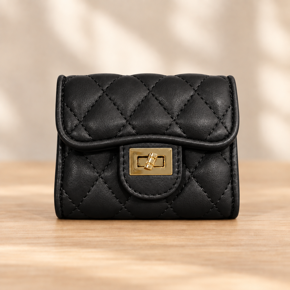Black quilted wallet with gold clasp on a warm wooden table