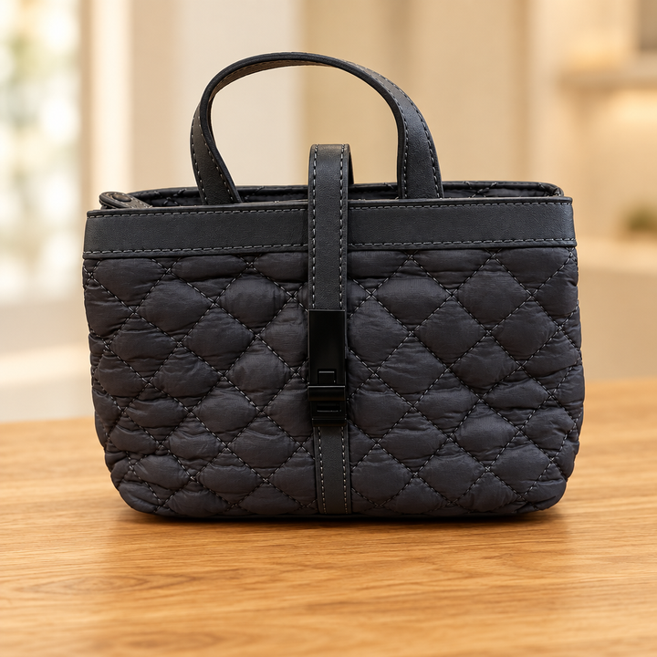 Charcoal quilted mini tote bag on a wooden table against a soft neutral background