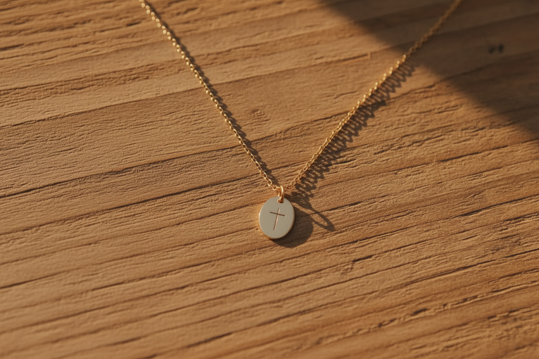 Gold cross necklace on warm wood, no props