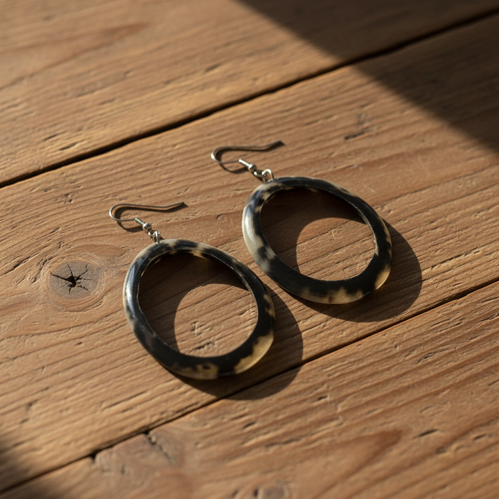 Tortoise shell hoop earrings on a wooden table
