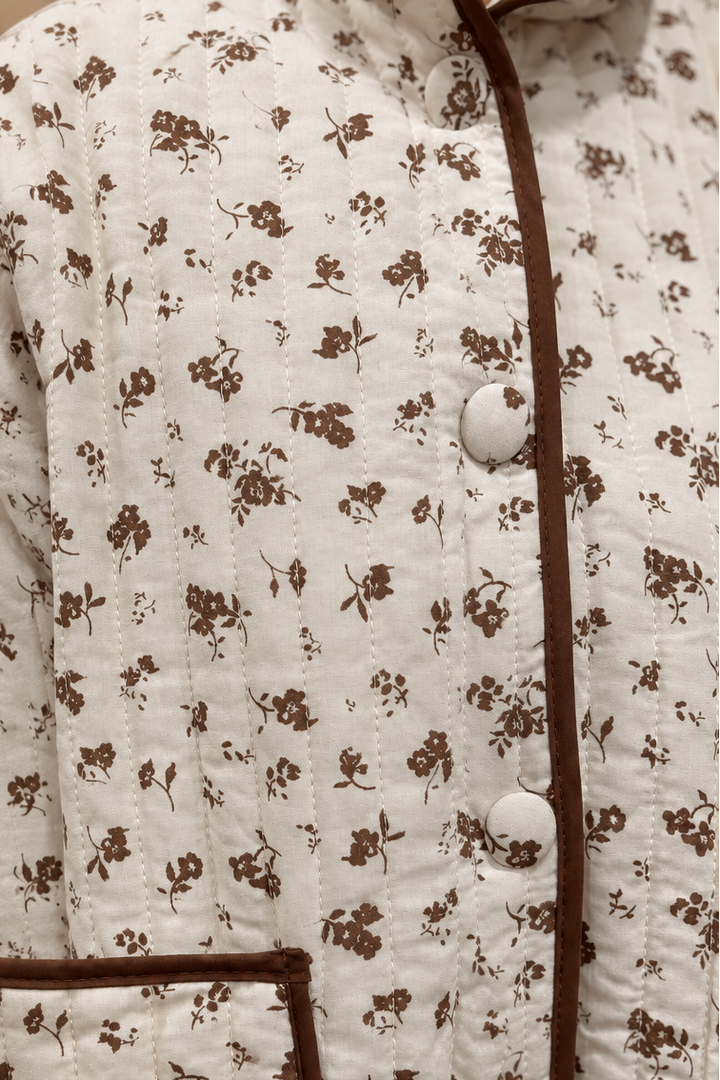 Close-up of floral quilted jacket print, contrast trim and snap buttons