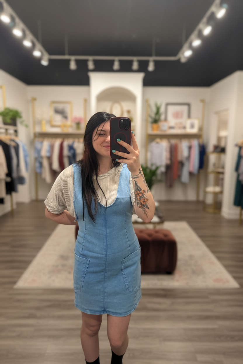 Sleeveless pocket mini dress on model with blurred boutique background
