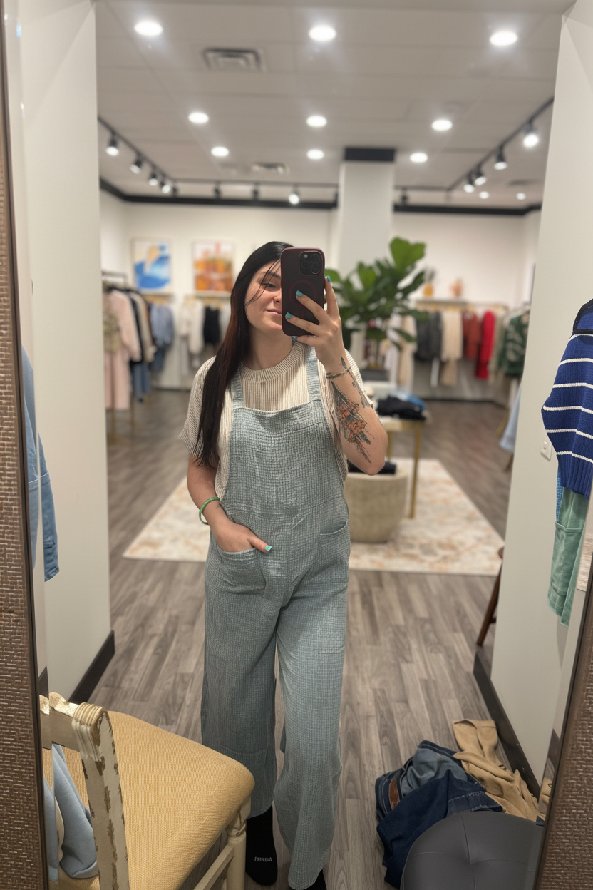 Blue grey textured wide leg jumpsuit on model with blurred boutique background