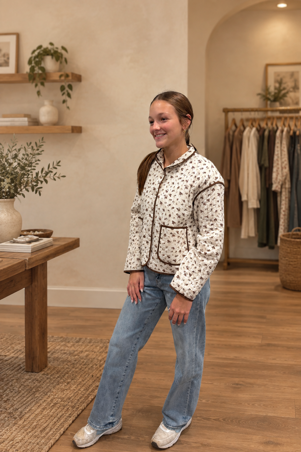 Side view of floral print quilted jacket in warm boutique setting