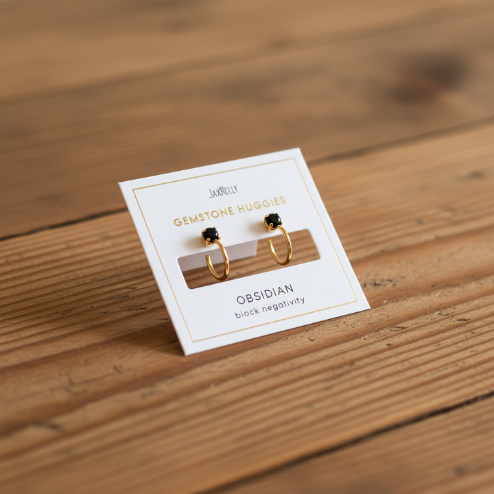 Obsidian gemstone gold huggie earrings on warm rustic wooden table lifestyle jewelry product photography
