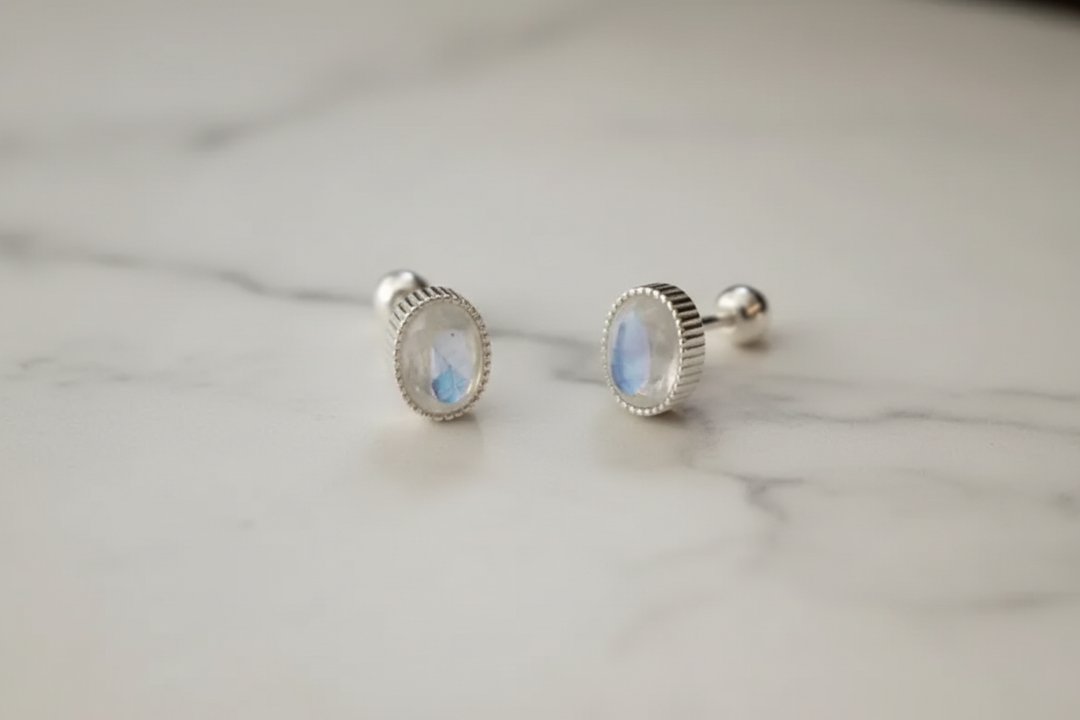 Moonstone earrings flat lay on marble