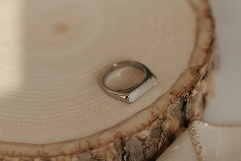 Silver signet ring on wood slice
