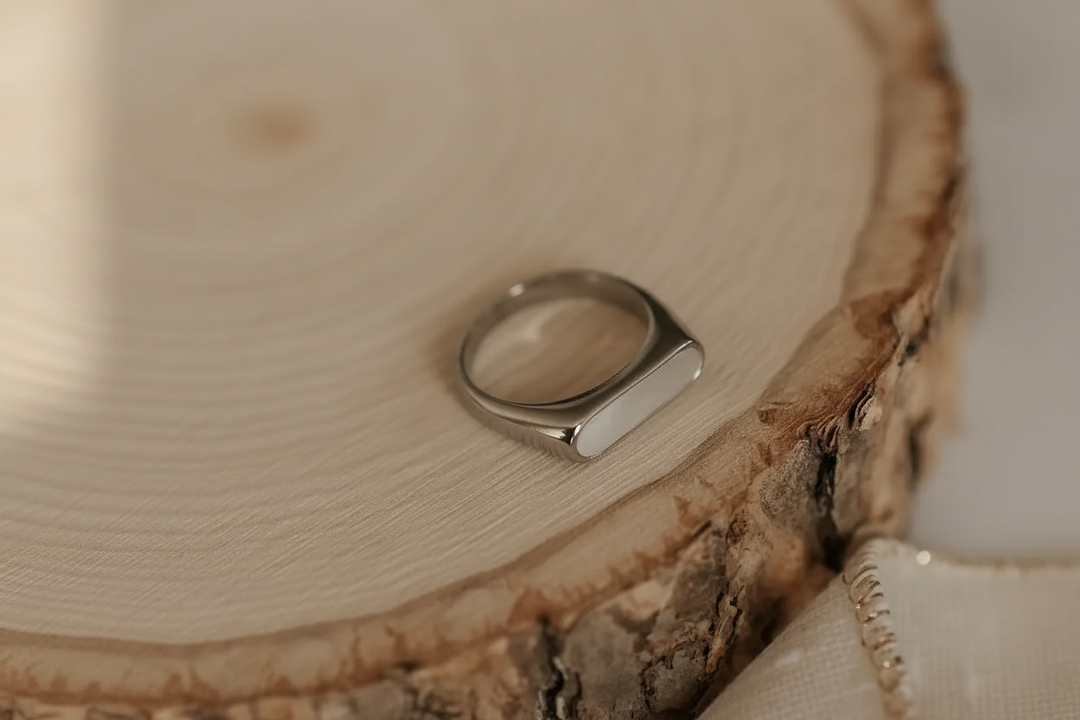 Silver signet ring on wood slice