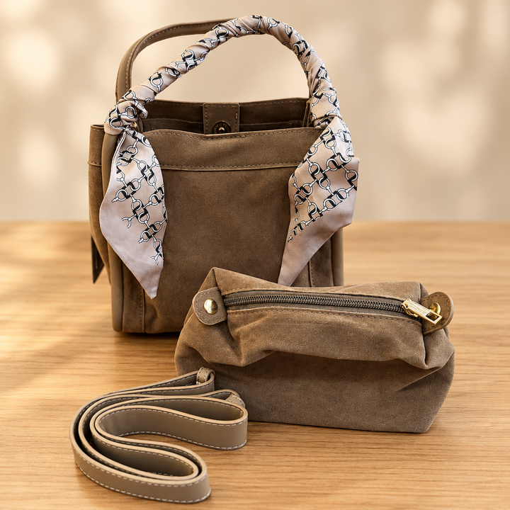 Brown handbag set with chain-print scarf, matching pouch and strap on a warm wooden table against a soft neutral background