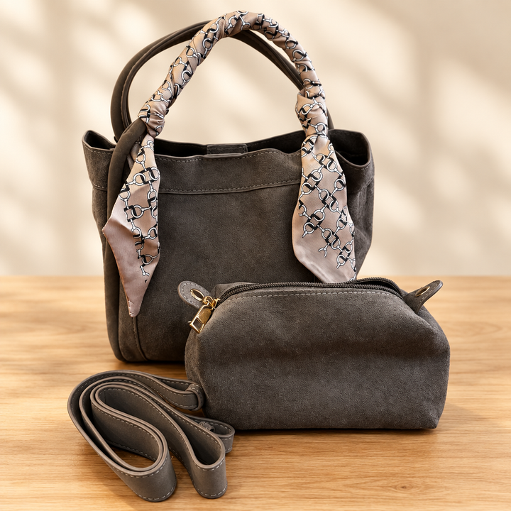 Taupe handbag set with patterned scarf, matching pouch and strap on a warm wooden table against a soft neutral background